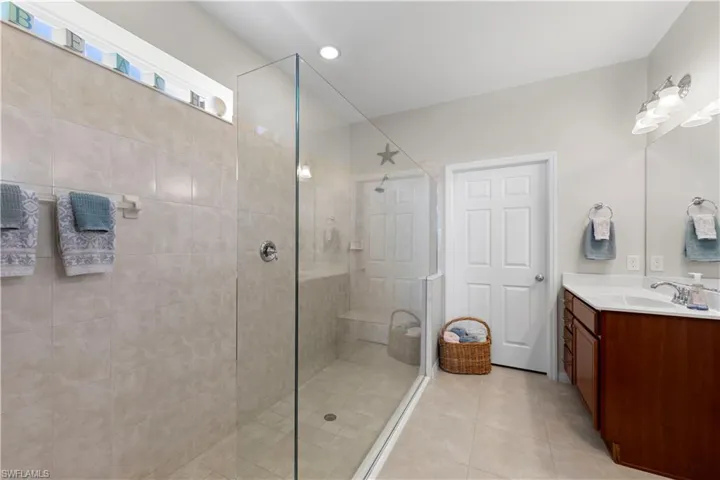 Full bathroom with vanity, walk in shower, and tile patterned floors