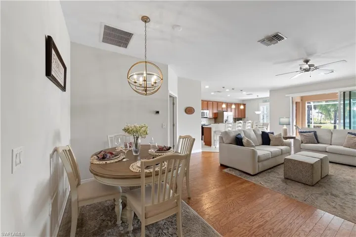 Dining space featuring light wood-style floors, a chandelier, and ceiling fan