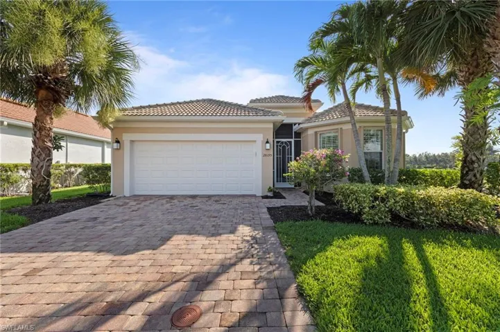 Mediterranean / spanish-style home featuring stucco siding, a garage, decorative driveway, and a front yard