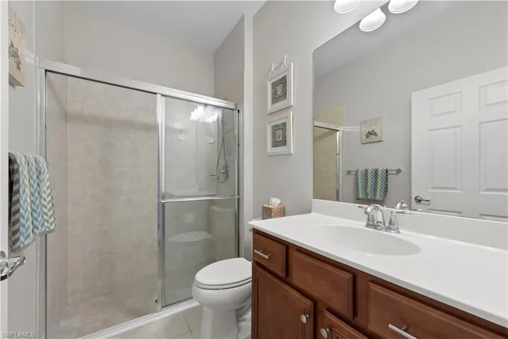 Full bathroom featuring vanity, a stall shower, and tile patterned floors
