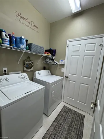 Laundry room with light tile patterned floors and independent washer and dryer
