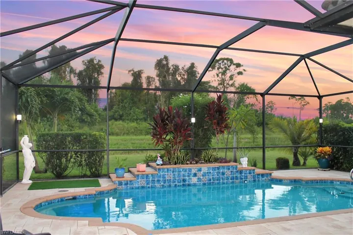 Pool at dusk featuring a lanai