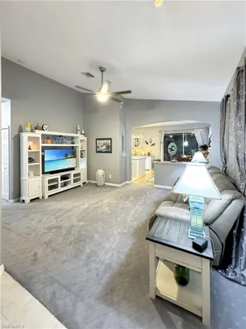 Living room with upgraded carpet, vaulted ceiling and oversized ceiling fan