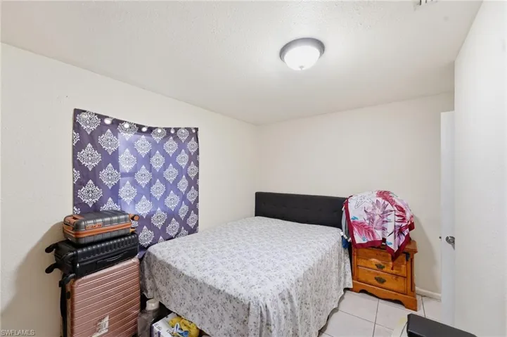 Bedroom with a textured ceiling and tile patterned floors
