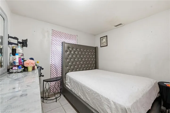 Bedroom with light tile patterned flooring