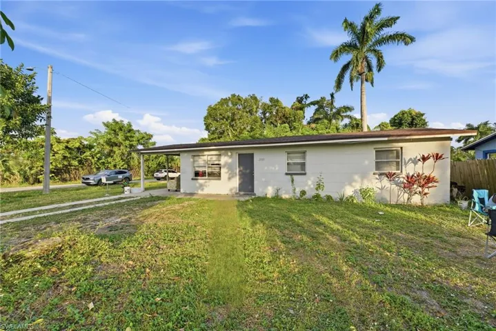 Ranch-style home with a front yard and an attached carport