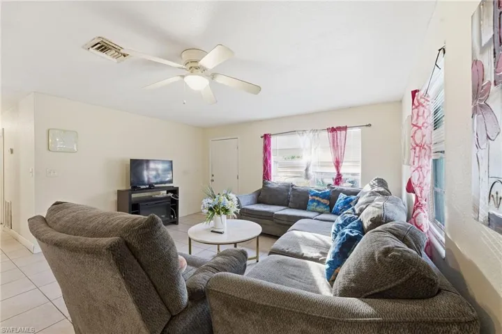 Living room with light tile patterned flooring and a ceiling fan
