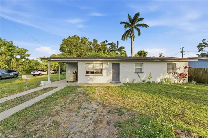 View of front of house featuring a carport, concrete block siding, and a porch
