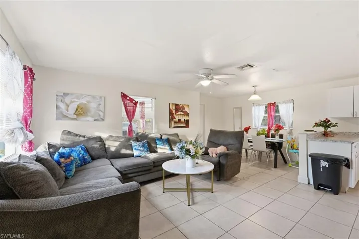 Living room with light tile patterned flooring and a ceiling fan