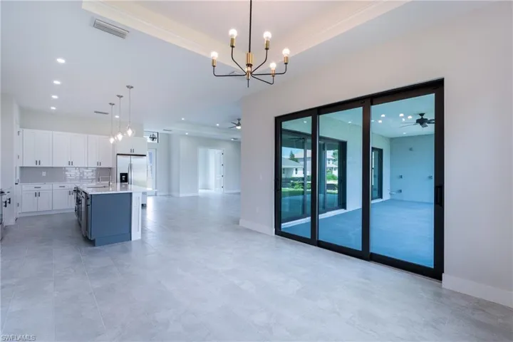 Kitchen with ceiling fan, two tone color scheme, hanging lights, a kitchen island, and open floor plan