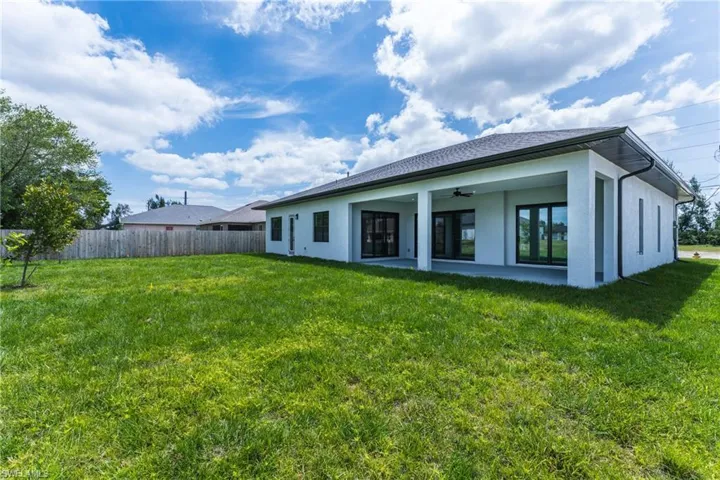 Rear view of property featuring a ceiling fan, a patio area, and stucco siding