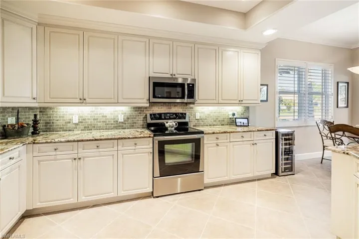 upgraded cabinets, granite, backsplash,  undercounted lighting, wine cooler