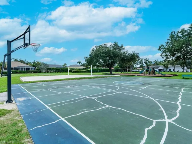 View of sport court with a playground and a yard