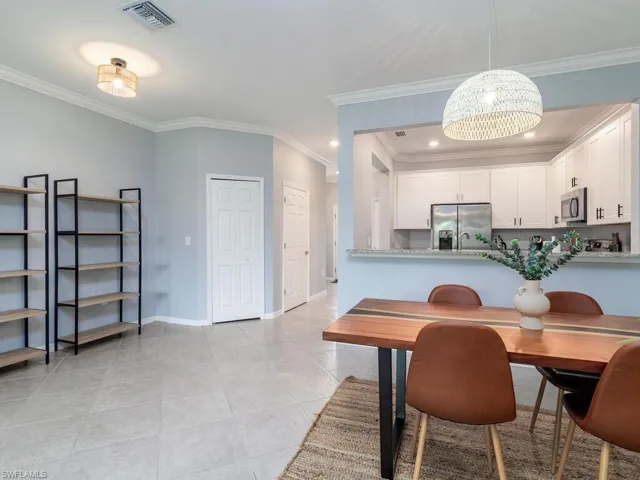 Tiled dining space featuring ornamental molding