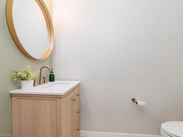 Bathroom featuring large vanity and toilet
