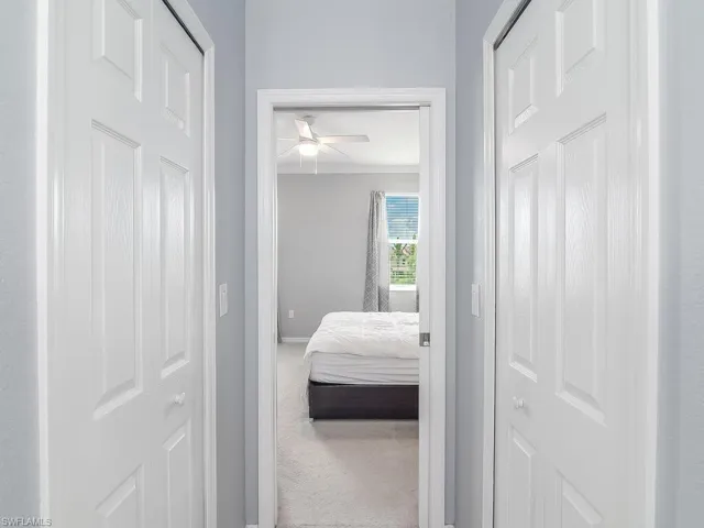 Hall with carpet flooring and crown molding
