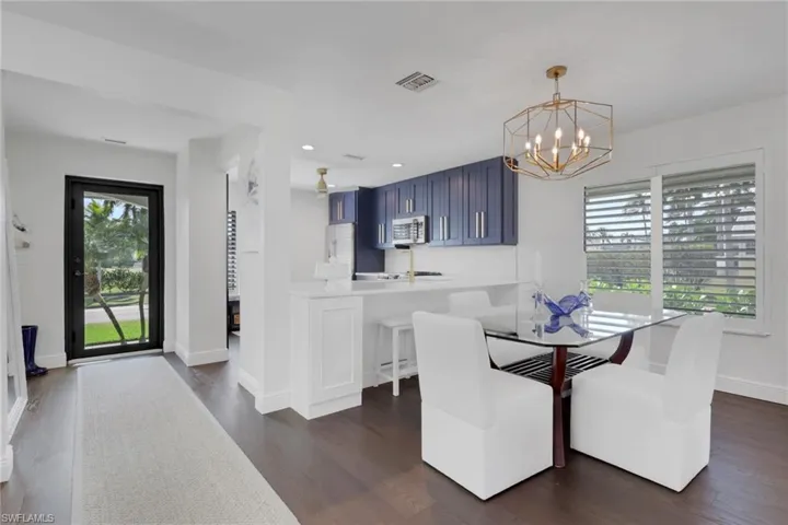 Dining area featuring dark wood-type flooring, a chandelier, and recessed lighting