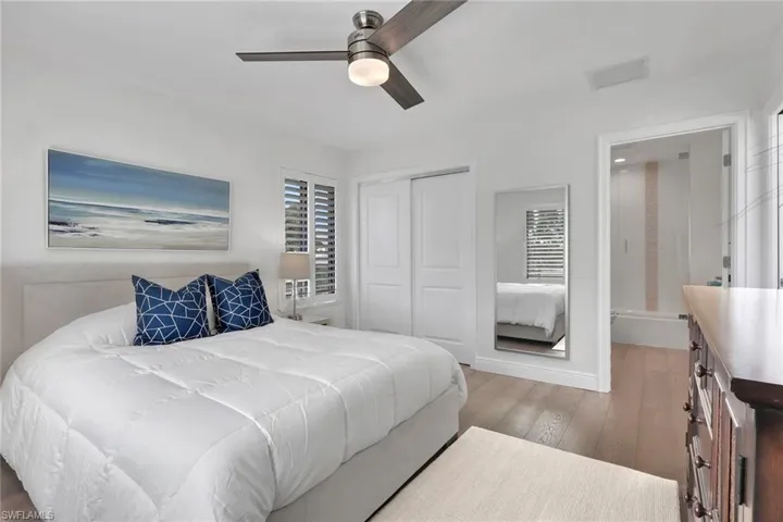 Bedroom with light wood-type flooring, a closet, and a ceiling fan