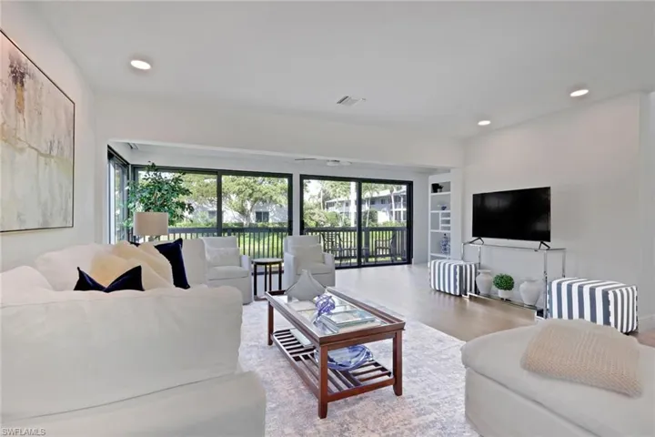 Living room with wood finished floors, plenty of natural light, and recessed lighting