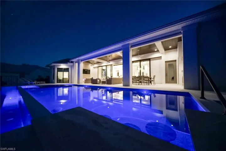 View of swimming pool featuring an infinity pool, a patio, and an outdoor hangout area