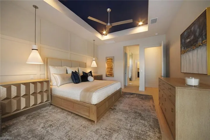 Bedroom with a tray ceiling and a ceiling fan