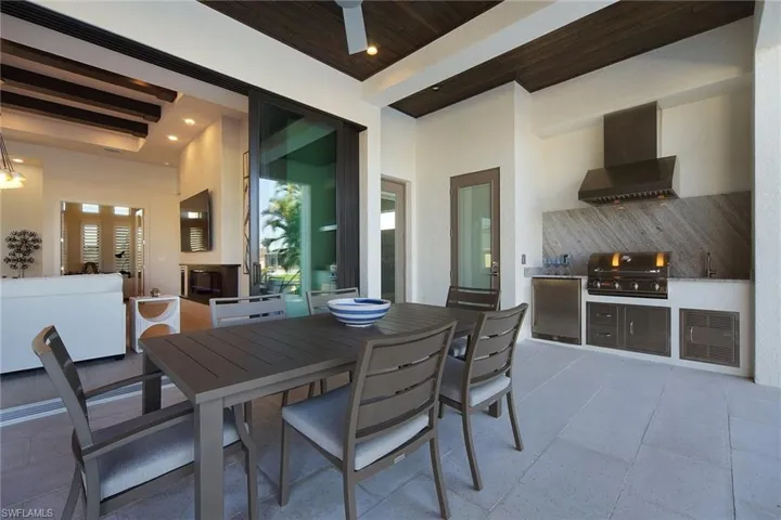 Dining space with wooden ceiling, wet bar, a high ceiling, recessed lighting, and light tile patterned flooring