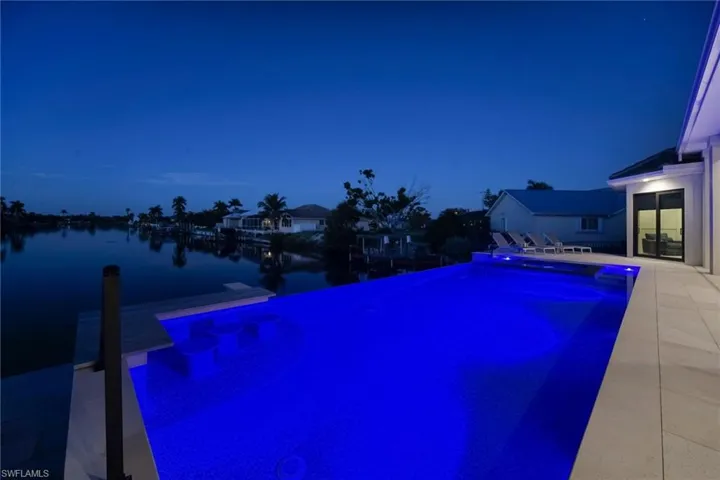 View of pool with an infinity pool, a patio, and a dock