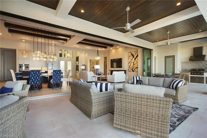 Living area with recessed lighting, a wood ceiling with exposed beams, and ceiling fan