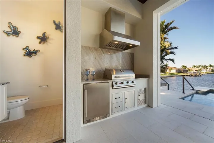 View of patio featuring a water view and exterior kitchen