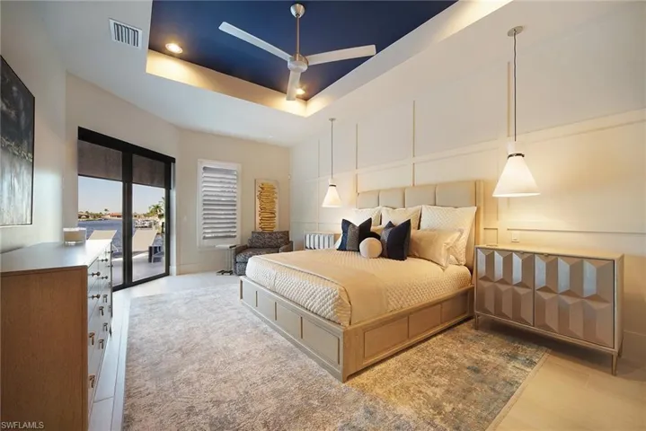 Bedroom with a tray ceiling, access to outside, ceiling fan, recessed lighting, and light wood-style floors