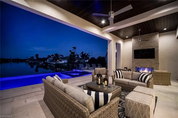 View of patio with outdoor lounge area, a ceiling fan, and a pool with connected hot tub