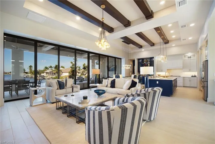 Living room featuring beam ceiling, recessed lighting, and a chandelier