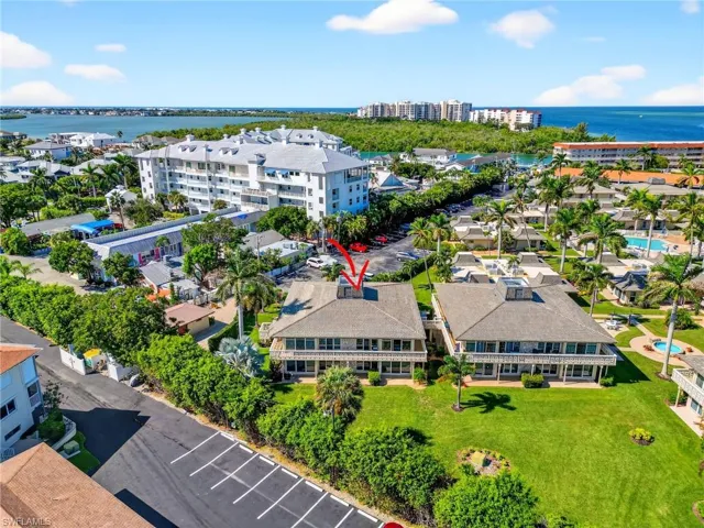 Drone / aerial view of a nearby body of water and apartment complex / building