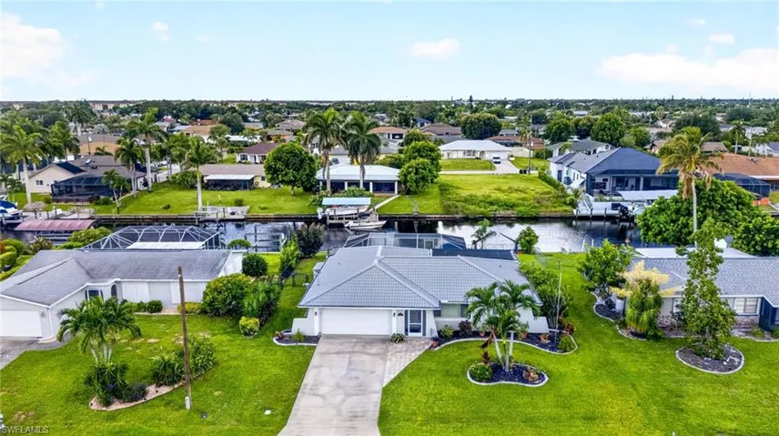 Single-story residence with an attached garage, featuring a tile roof and a paved driveway