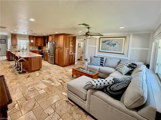 Spacious open-concept layout featuring a kitchen with wood cabinetry and stainless steel appliances