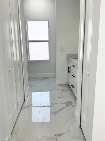 Bathroom with vanity and light marble finish flooring
