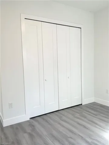 Unfurnished bedroom featuring a closet and wood finished floors