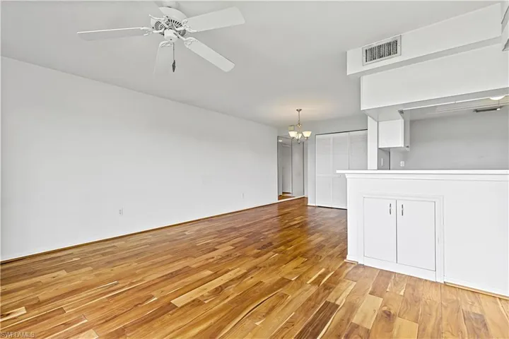 Unfurnished living room with light hardwood / wood-style flooring and ceiling fan with notable chandelier