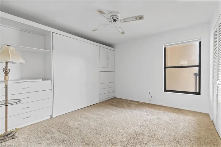 Unfurnished bedroom with light carpet and ceiling fan