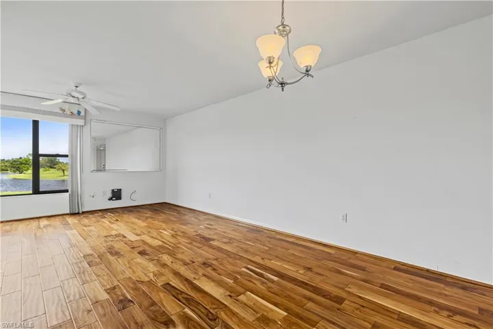 Unfurnished living room featuring light hardwood / wood-style floors and ceiling fan with notable chandelier