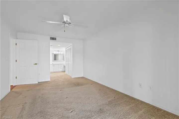 Carpeted empty room with ceiling fan