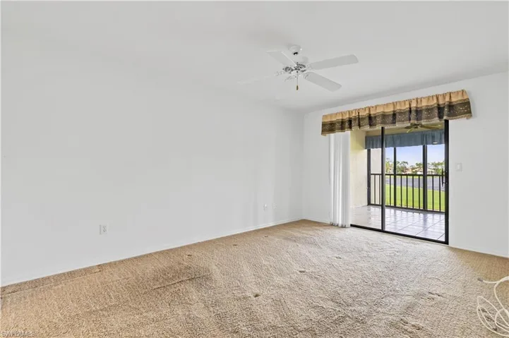 Carpeted empty room with ceiling fan