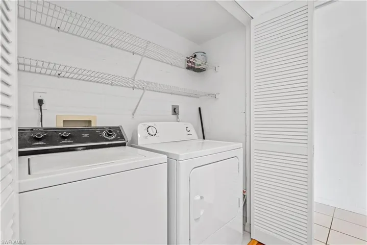 Laundry area featuring washing machine and dryer and light tile patterned floors