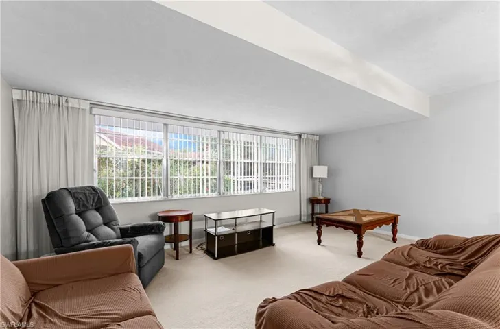 Carpeted living area featuring healthy amount of natural light