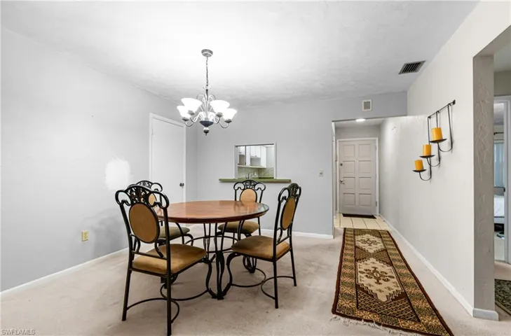 Dining room featuring light carpet and a chandelier