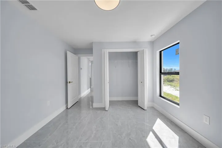 Unfurnished bedroom featuring a closet and light marble finish floors
