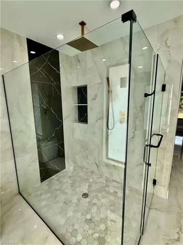Bathroom featuring a marble finish shower, recessed lighting, and marble tiled flooring