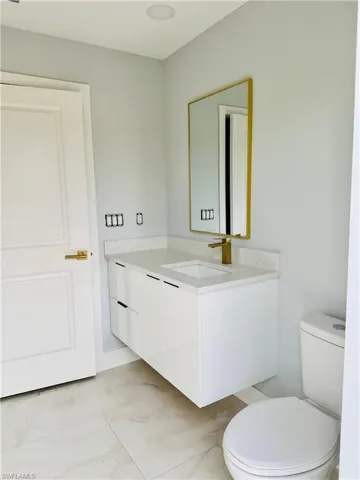 Half bathroom with vanity and toilet