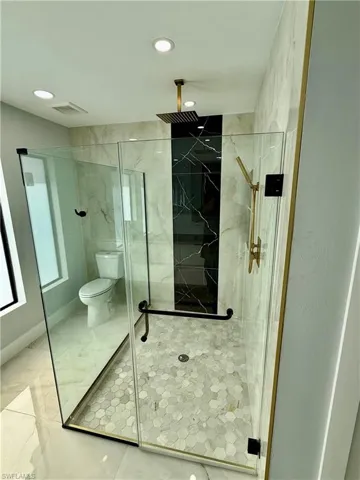 Full bathroom with a marble finish shower, marble finish floors, and recessed lighting