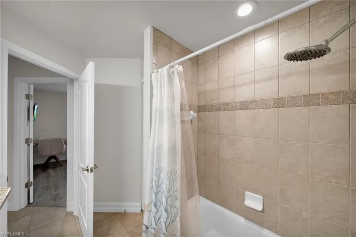 Full bath with recessed lighting, shower / bath combo, tile patterned floors, and baseboards